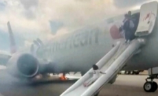 Passengers flee on emergency slide after American Airlines Boeing in Denver suffers landing gear fire