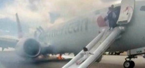 Passengers flee on emergency slide after American Airlines Boeing in Denver suffers landing gear fire